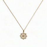 A Snowflake Pendant with White Cubic Zirconia Accent Necklace by Skōsh Jewelry, featuring a snowflake pendant accented with small clear stones on a fine gold chain, displayed against a white background.