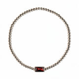 A January Birthstone Garnet Cubic Zirconia Baguette Bracelet by Skōsh Jewelry, featuring a strand of polished sterling silver beads on a stretch cord with a rectangular deep red baguette stone at the center, displayed against a white background.