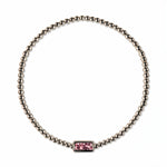 An October Birthstone Pink Cubic Zirconia Baguette Bracelet by Skōsh Jewelry, featuring a strand of polished sterling silver beads on a stretch cord with a rectangular pink baguette stone at the center, displayed against a white background.