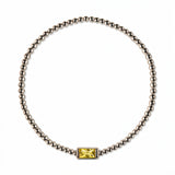 A November Birthstone Citrine Cubic Zirconia Baguette Bracelet by Skōsh Jewelry, featuring a strand of polished sterling silver beads on a stretch cord with a rectangular yellow baguette stone at the center, displayed against a white background.