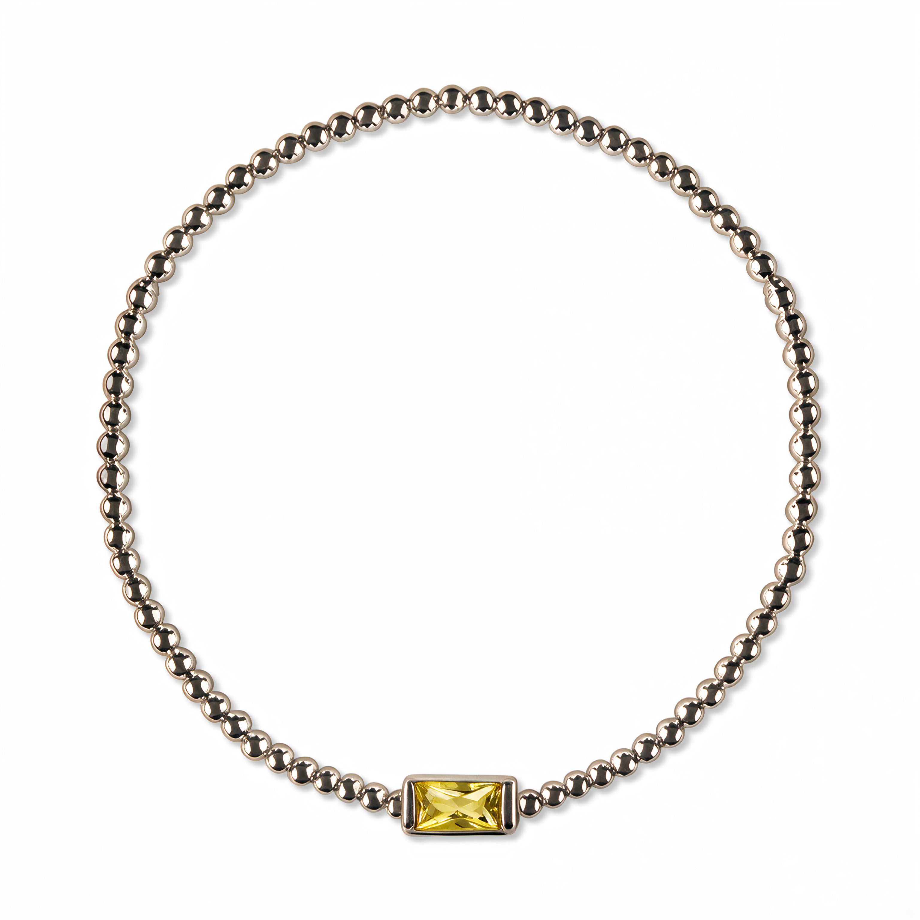 A November Birthstone Citrine Cubic Zirconia Baguette Bracelet by Skōsh Jewelry, featuring a strand of polished sterling silver beads on a stretch cord with a rectangular yellow baguette stone at the center, displayed against a white background.