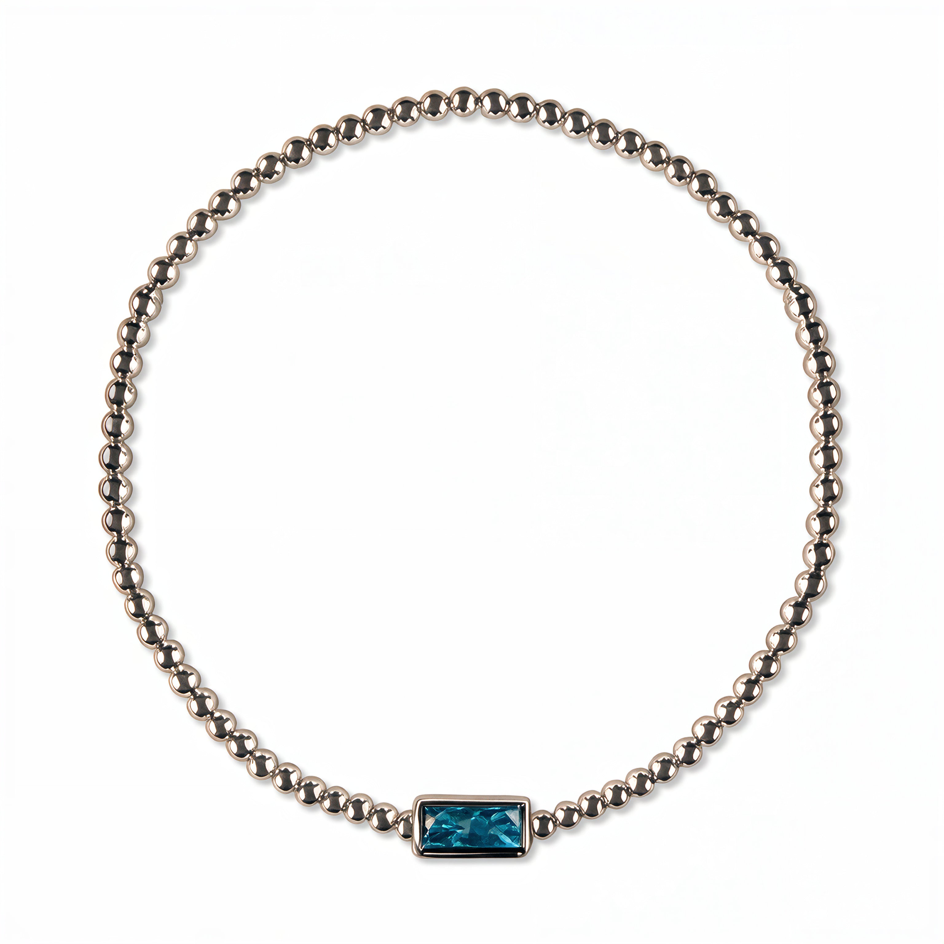 A December Birthstone Aqua Cubic Zirconia Baguette Bracelet by Skōsh Jewelry, featuring a strand of polished sterling silver beads on a stretch cord with a rectangular blue baguette stone at the center, displayed against a white background.