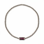 A February Birthstone Amethyst Cubic Zirconia Baguette Bracelet by Skōsh Jewelry, featuring a strand of polished sterling silver beads on a stretch cord with a rectangular purple baguette stone at the center, displayed against a white background.