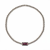 A February Birthstone Amethyst Cubic Zirconia Baguette Bracelet by Skōsh Jewelry, featuring a strand of polished sterling silver beads on a stretch cord with a rectangular purple baguette stone at the center, displayed against a white background.