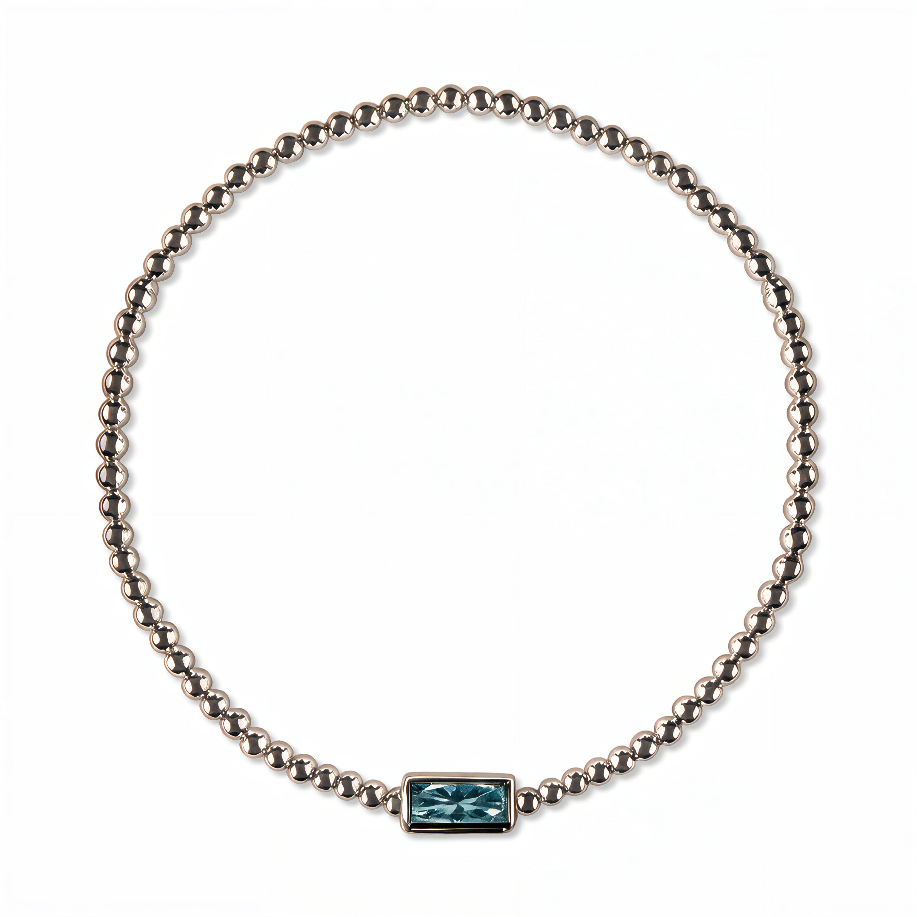 A March Birthstone Light Sapphire Cubic Zirconia Baguette Bracelet by Skōsh Jewelry, featuring a strand of polished sterling silver beads on a stretch cord with a rectangular light blue baguette stone at the center, displayed against a white background.