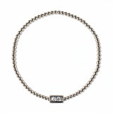 An April Birthstone White Cubic Zirconia Baguette Bracelet by Skōsh Jewelry, featuring a strand of polished sterling silver beads on a stretch cord with a rectangular clear baguette stone at the center, displayed against a white background.