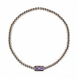 A June Birthstone Lavender Cubic Zirconia Baguette Bracelet by Skōsh Jewelry, featuring a strand of polished sterling silver beads on a stretch cord with a rectangular light purple baguette stone at the center, displayed against a white background.