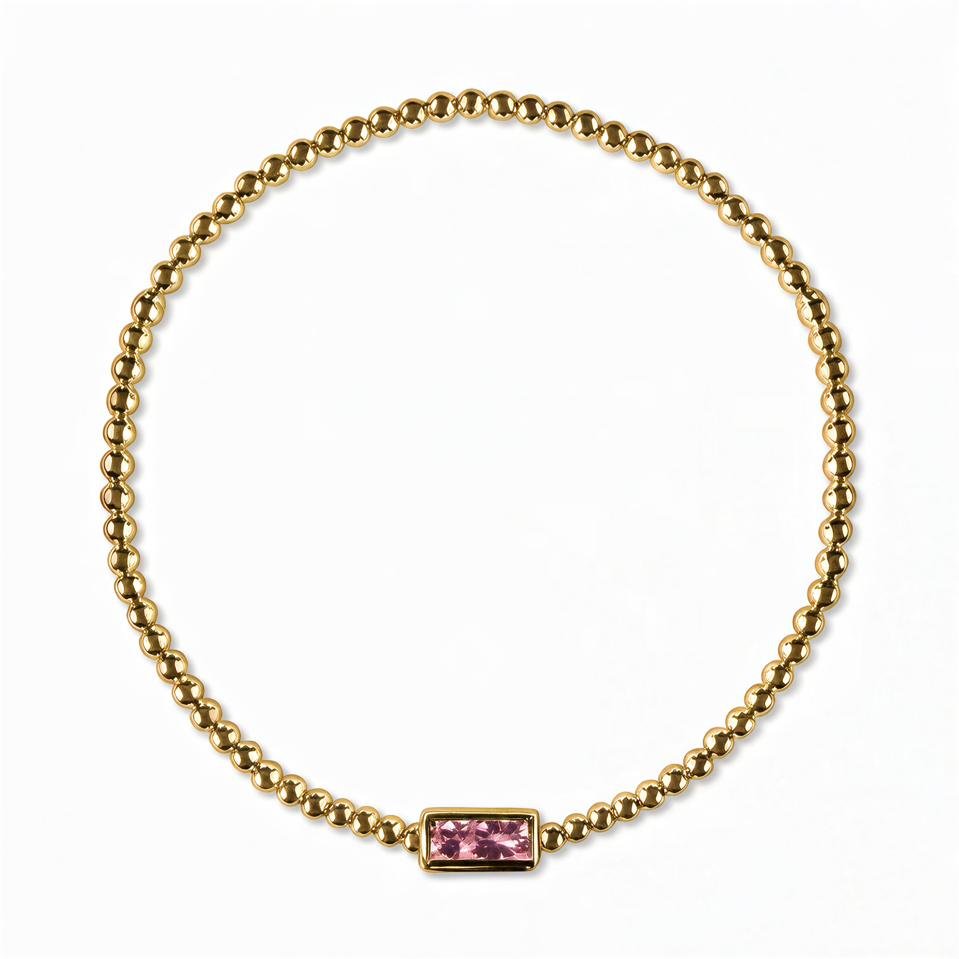 An October Birthstone Pink Cubic Zirconia Baguette Bracelet by Skōsh Jewelry, featuring a strand of polished gold beads on a stretch cord with a rectangular pink baguette stone at the center, displayed against a white background.