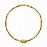 A November Birthstone Citrine Cubic Zirconia Baguette Bracelet by Skōsh Jewelry, featuring a strand of polished gold beads on a stretch cord with a rectangular yellow baguette stone at the center, displayed against a white background.
