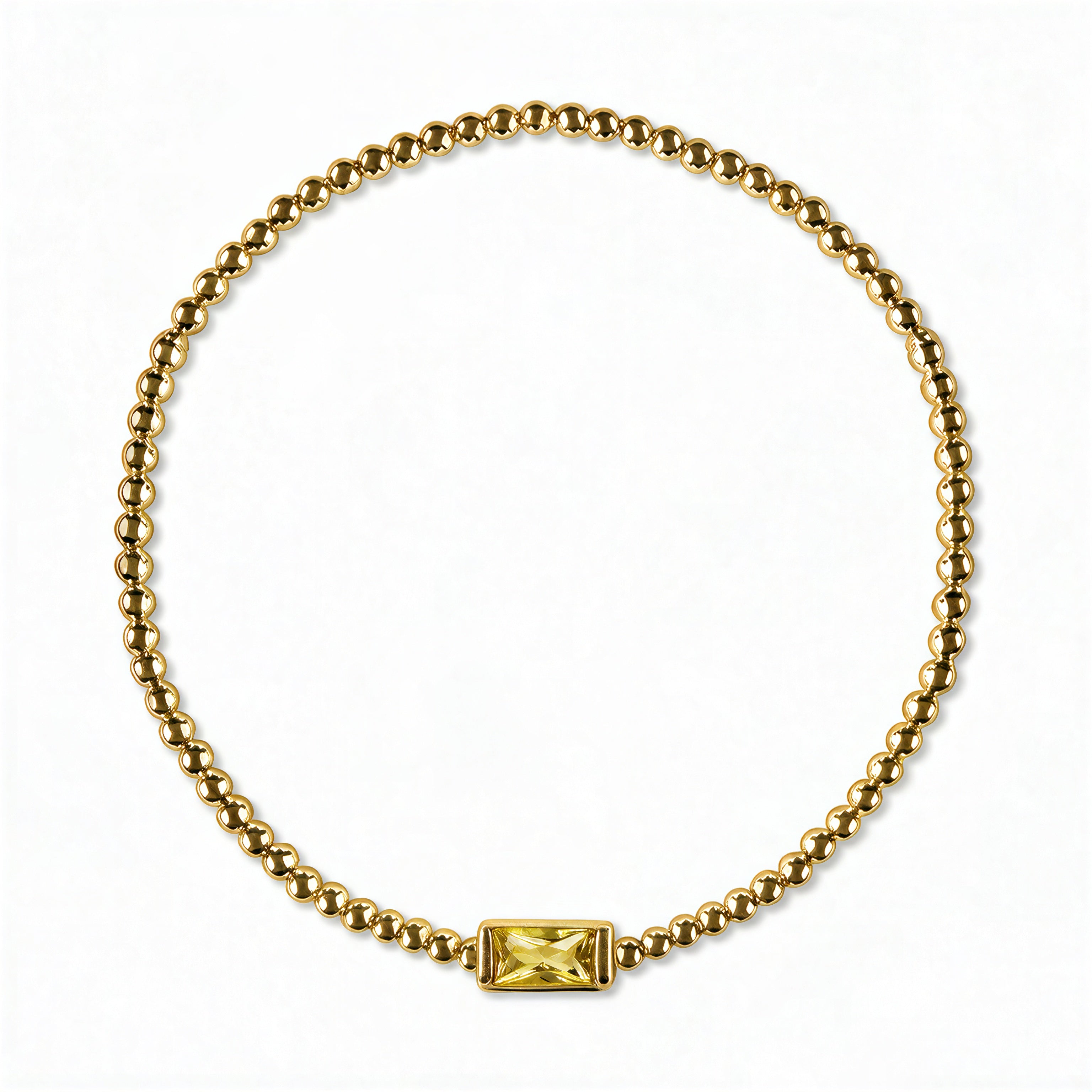 A November Birthstone Citrine Cubic Zirconia Baguette Bracelet by Skōsh Jewelry, featuring a strand of polished gold beads on a stretch cord with a rectangular yellow baguette stone at the center, displayed against a white background.