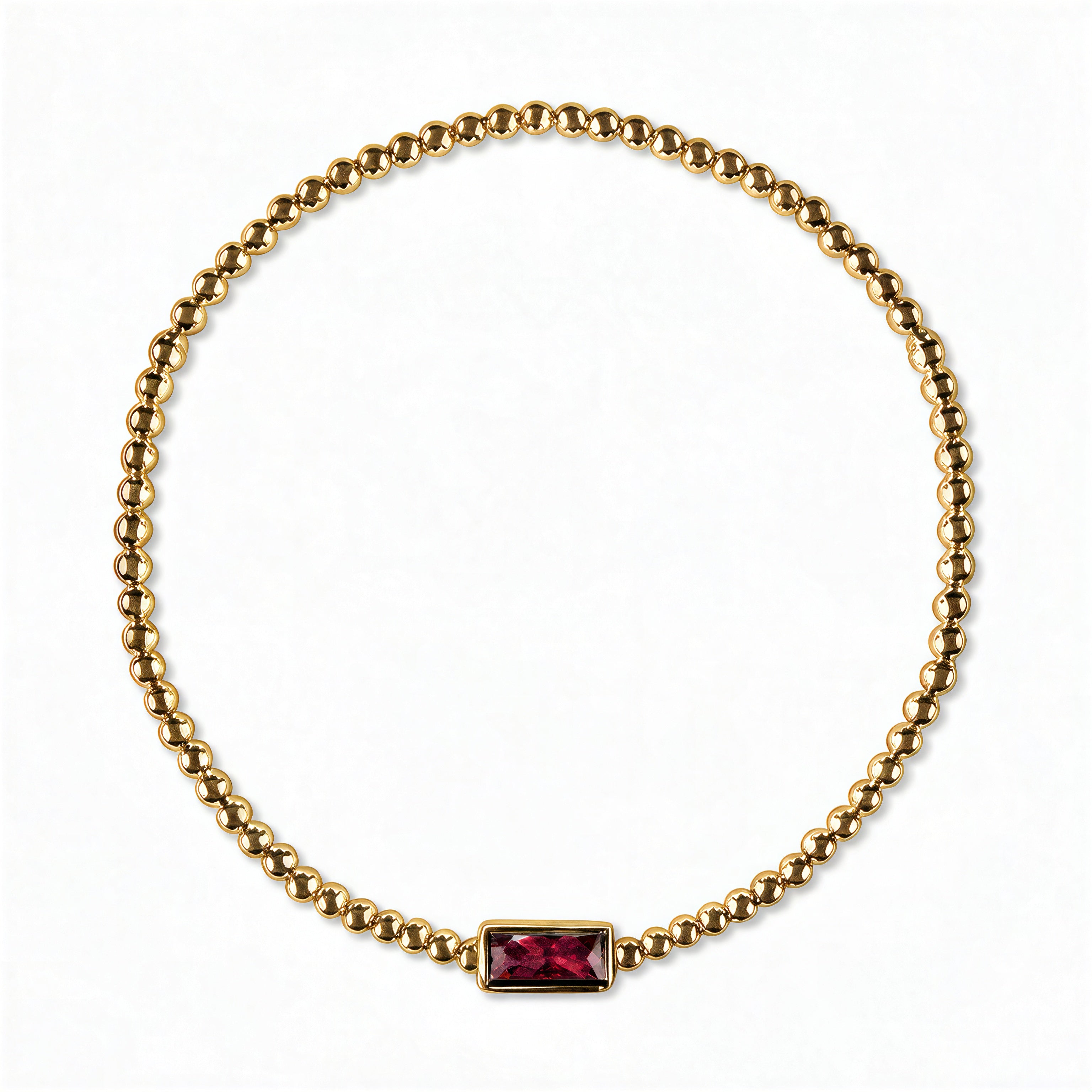 A July Birthstone Ruby Cubic Zirconia Baguette Bracelet by Skōsh Jewelry, featuring a strand of polished gold beads on a stretch cord with a rectangular red baguette stone at the center, displayed against a white background.