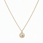A Mustard Seed Pendant Necklace by Skōsh Jewelry, featuring a small round pendant with a mustard seed set beneath a mountain outline on a fine gold chain, displayed against a white background.