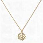 A Poinsettia December Flower Pendant Necklace by Skōsh Jewelry, featuring an open cutout poinsettia flower pendant on a fine gold chain, displayed against a white background.