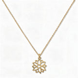 A Poinsettia December Flower Pendant Necklace by Skōsh Jewelry, featuring an open cutout poinsettia flower pendant on a fine gold chain, displayed against a white background.