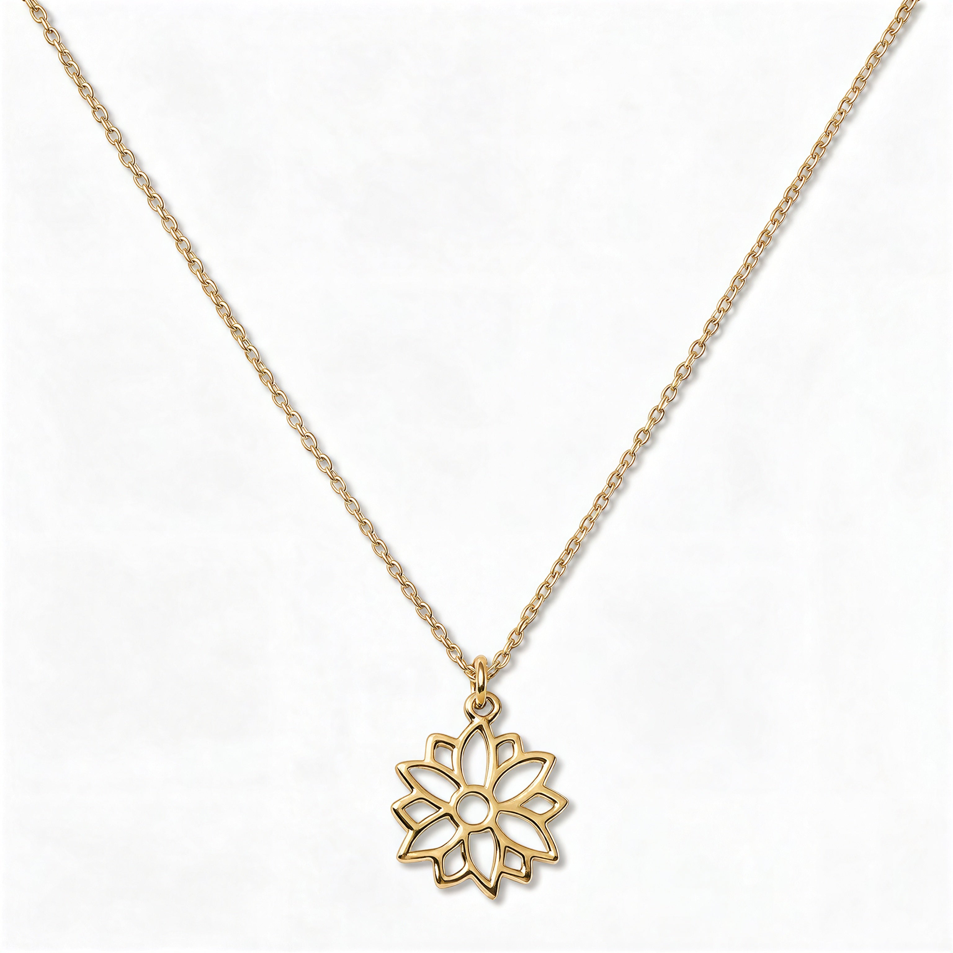 A Poinsettia December Flower Pendant Necklace by Skōsh Jewelry, featuring an open cutout poinsettia flower pendant on a fine gold chain, displayed against a white background.