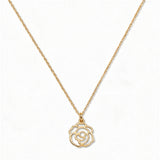 A Rose June Flower Pendant Necklace by Skōsh Jewelry, featuring an open cutout rose flower pendant on a fine gold chain, displayed against a white background.