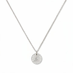A Ray of SONshine Etched Disc Pendant Necklace by Skōsh Jewelry, featuring a round disc etched with radiating sun rays on a fine sterling silver chain, displayed against a white background.