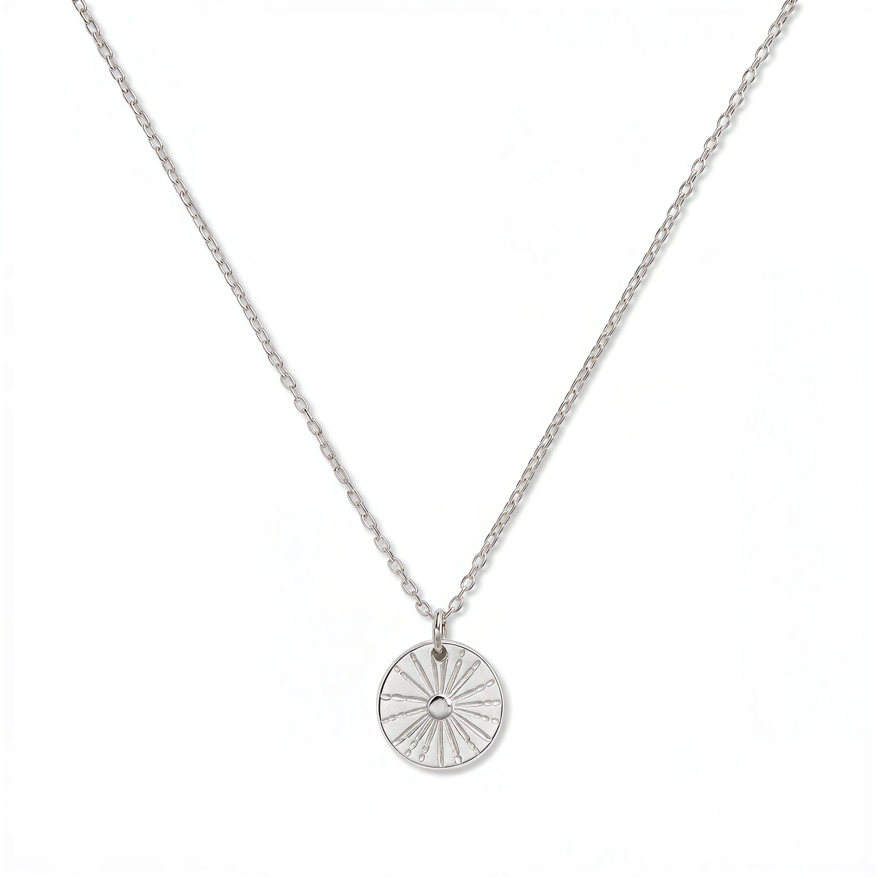 A Ray of SONshine Etched Disc Pendant Necklace by Skōsh Jewelry, featuring a round disc etched with radiating sun rays on a fine sterling silver chain, displayed against a white background.