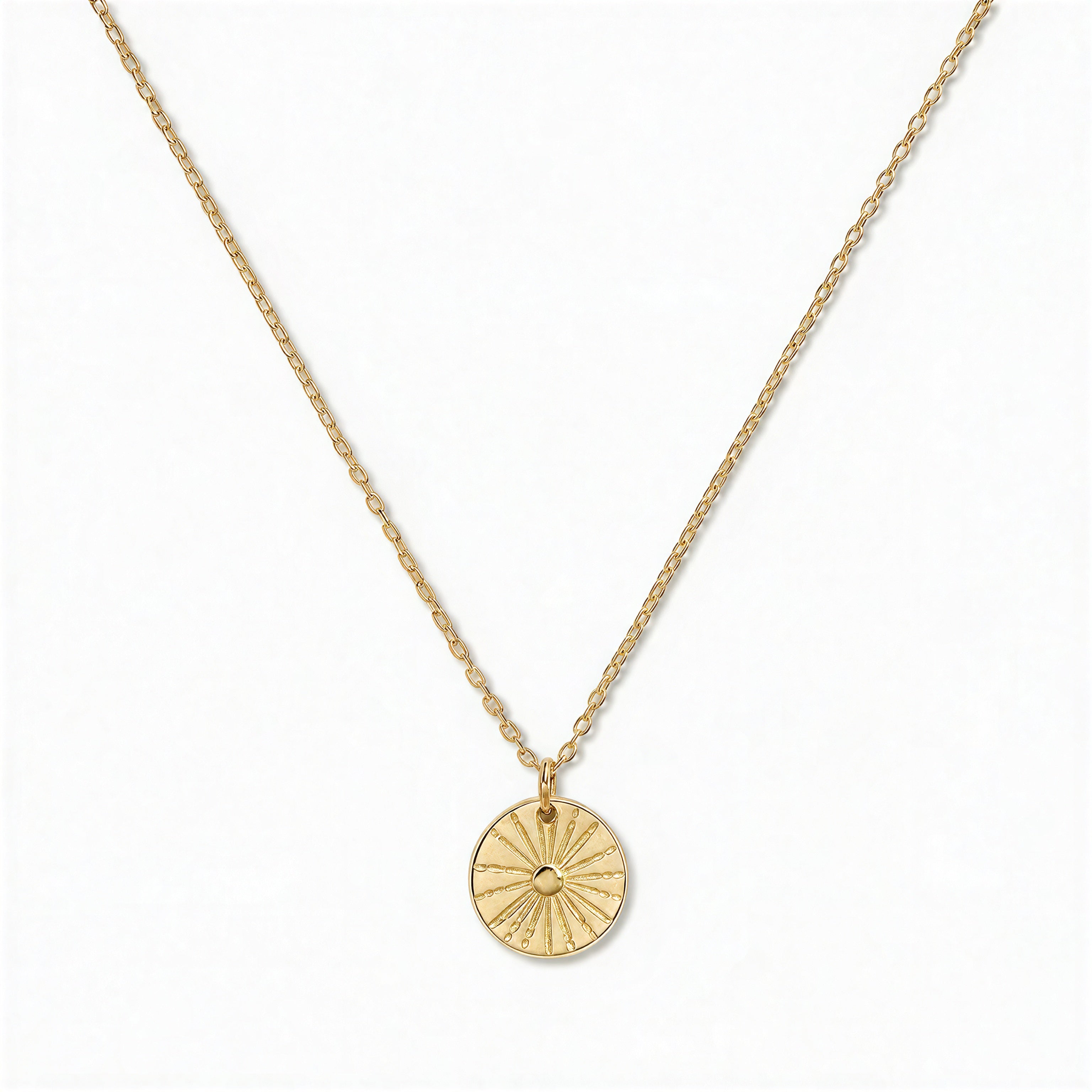 A Ray of SONshine Etched Disc Pendant Necklace by Skōsh Jewelry, featuring a round disc etched with radiating sun rays on a fine gold chain, displayed against a white background.