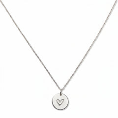 An Etched Heart Disc Pendant Necklace by Skōsh Jewelry, featuring a round disc etched with a small hand-drawn heart on a fine sterling silver chain, displayed against a white background.