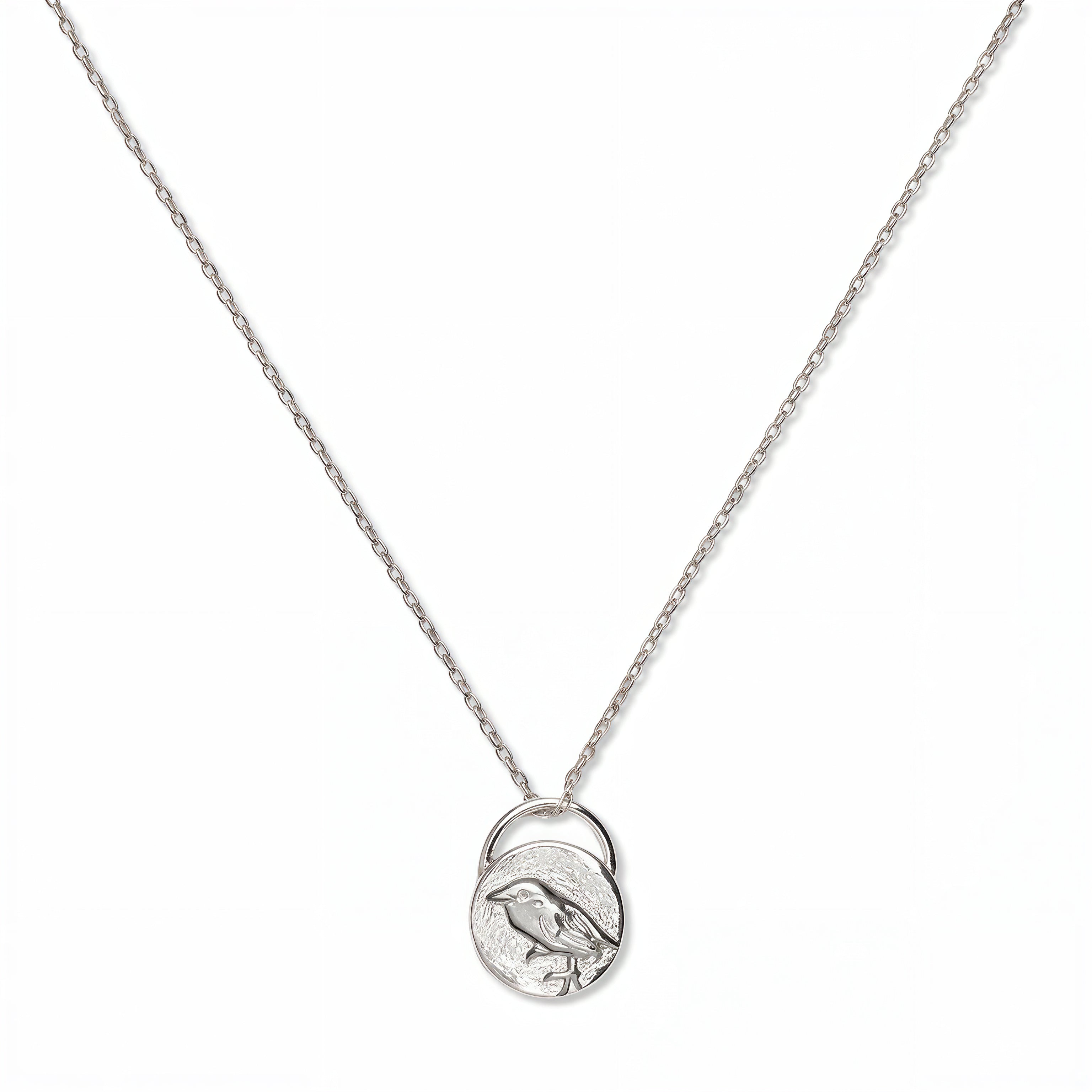 A Loved & Never Alone Bird Pendant Necklace by Skōsh Jewelry, featuring a rounded pendant with a cutout of a small bird on a fine sterling silver chain, displayed against a white background.