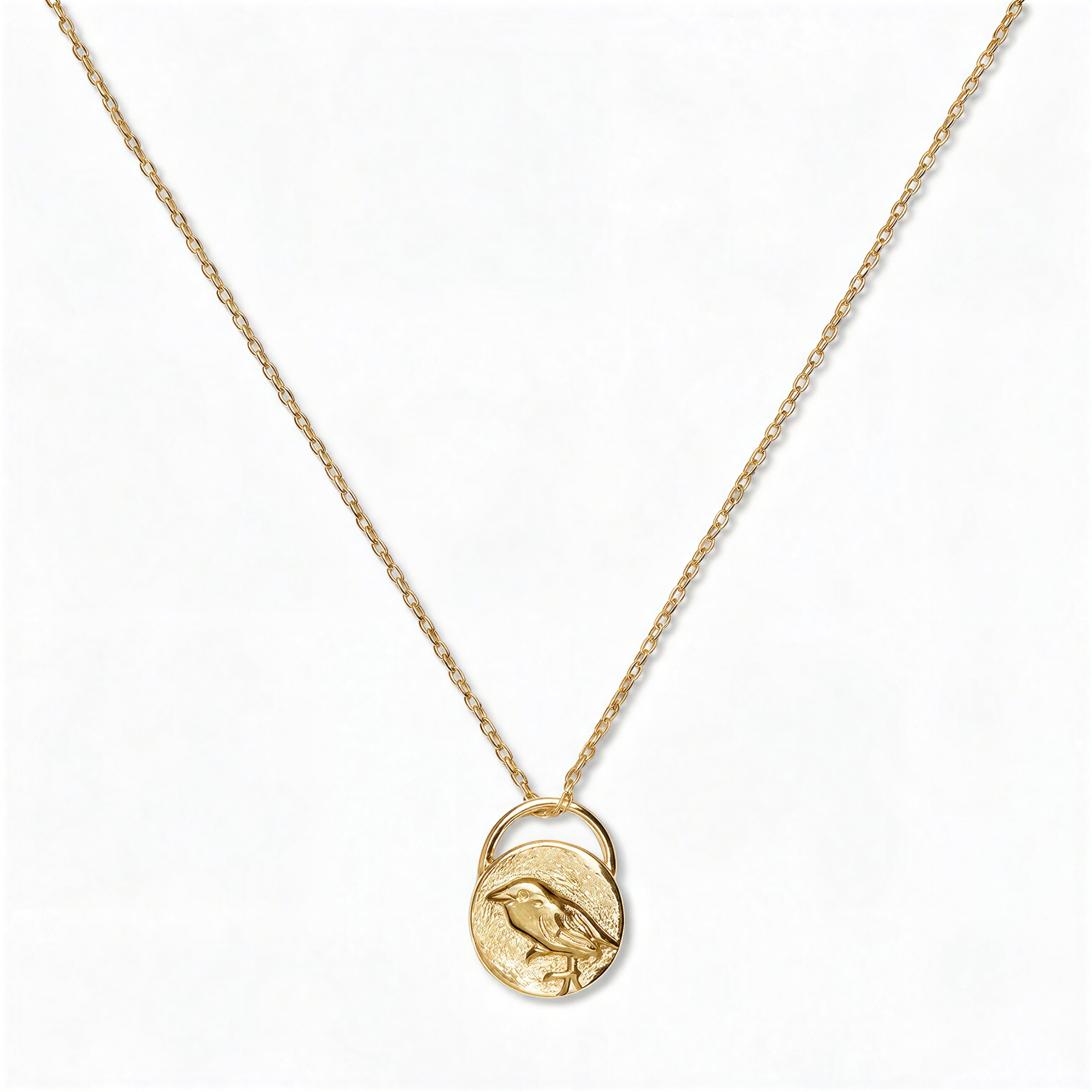 A Loved & Never Alone Bird Pendant Necklace by Skōsh Jewelry, featuring a rounded pendant with a cutout of a small bird on a fine gold chain, displayed against a white background.