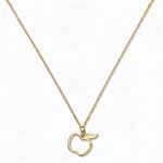 A Cut Out Apple Pendant Necklace by Skōsh Jewelry, featuring an open cutout outline of an apple on a fine gold chain, displayed against a white background.