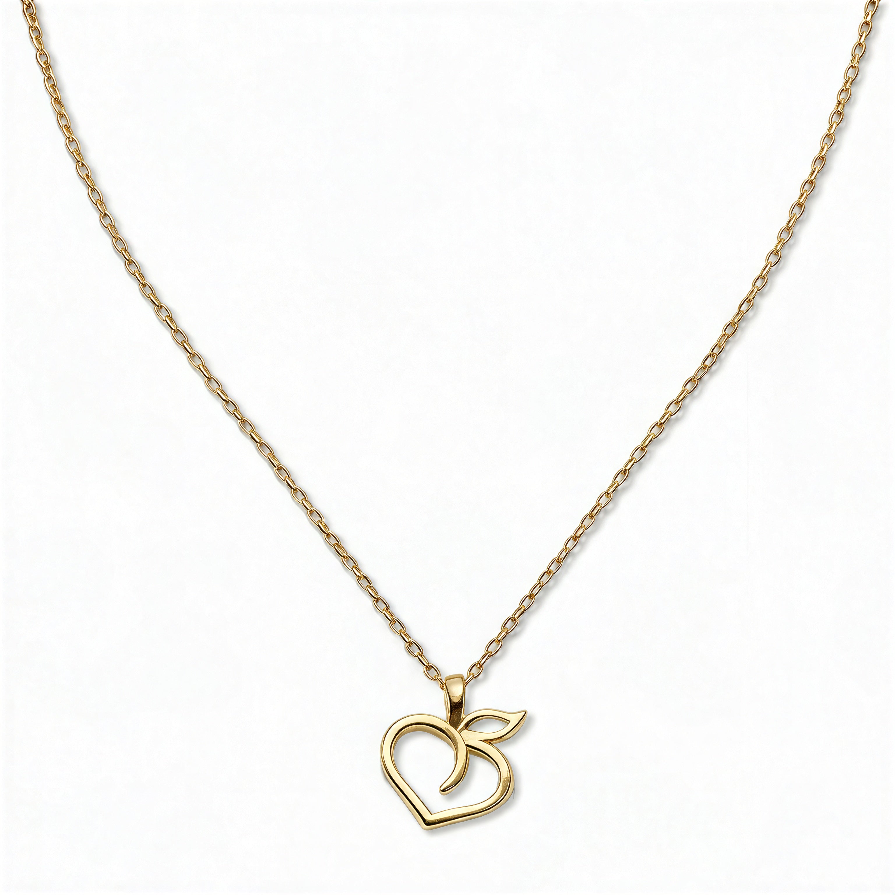 A Peach Pendant Necklace by Skōsh Jewelry, featuring an open outline of a peach with a leaf on a fine gold chain, displayed against a white background.