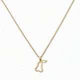 A Pear Pendant Necklace by Skōsh Jewelry, featuring an open outline of a pear on a fine gold chain, displayed against a white background.