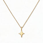 A Starlight Pendant Necklace by Skōsh Jewelry, featuring a sleek four-point star pendant on a fine gold chain, displayed against a white background.