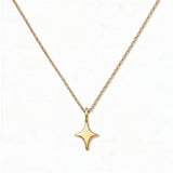 A Starlight Pendant Necklace by Skōsh Jewelry, featuring a sleek four-point star pendant on a fine gold chain, displayed against a white background.