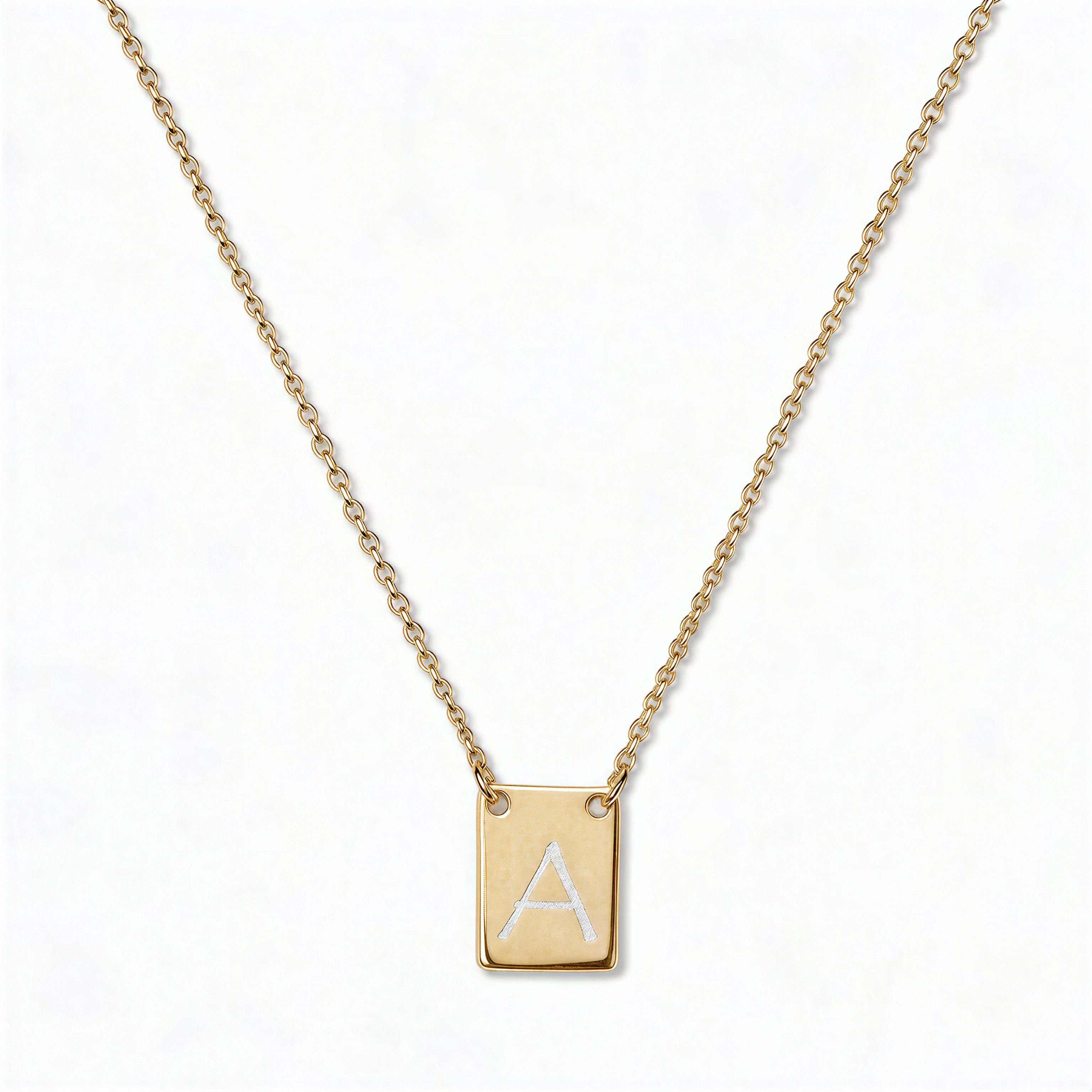 An Engraved Initial Necklace Letter A by Skōsh Jewelry, featuring a small rectangular tag engraved with the letter A on a fine gold chain, displayed against a white background.