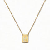 An Engraved Initial Necklace Letter B by Skōsh Jewelry, featuring a small rectangular tag engraved with the letter B on a fine gold chain, displayed against a white background.