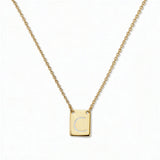 An Engraved Initial Necklace Letter C by Skōsh Jewelry, featuring a small rectangular tag engraved with the letter C on a fine gold chain, displayed against a white background.