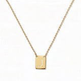 An Engraved Initial Necklace Letter J by Skōsh Jewelry, featuring a small rectangular tag engraved with the letter J on a fine gold chain, displayed against a white background.