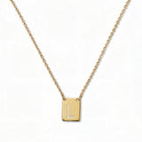 An Engraved Initial Necklace Letter L by Skōsh Jewelry, featuring a small rectangular tag engraved with the letter L on a fine gold chain, displayed against a white background.