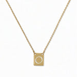An Engraved Initial Necklace Letter O by Skōsh Jewelry, featuring a small rectangular tag engraved with the letter O on a fine gold chain, displayed against a white background.