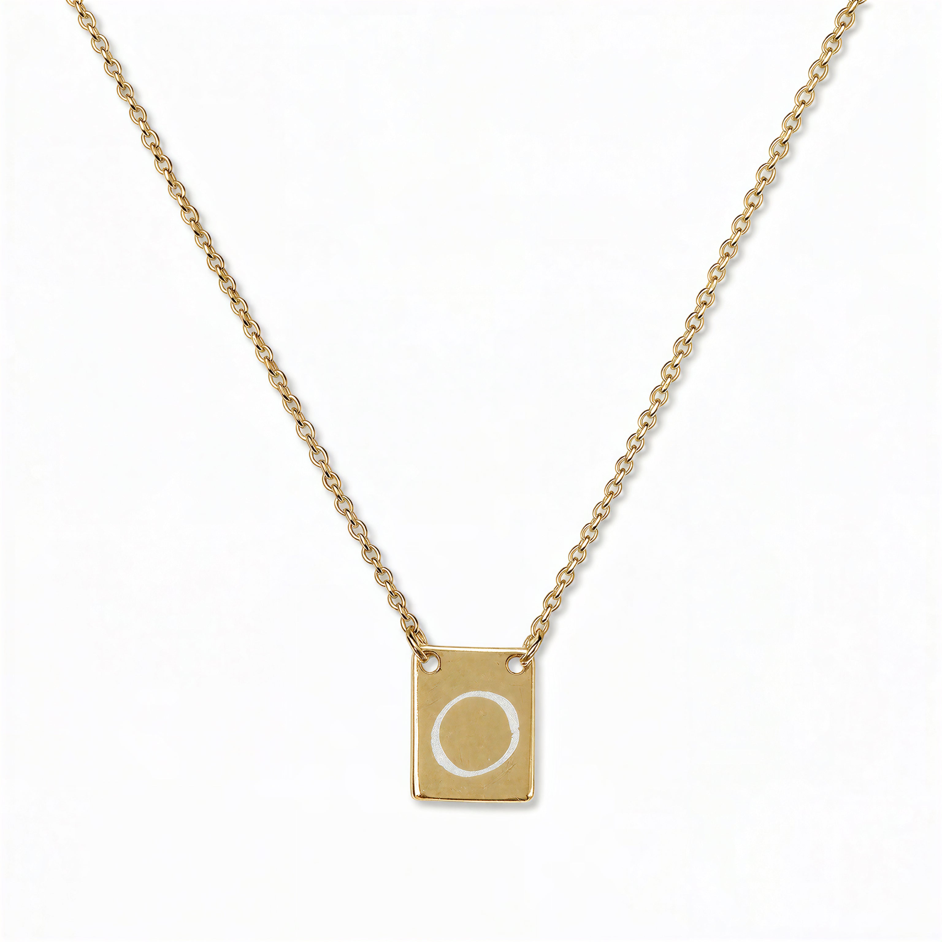 An Engraved Initial Necklace Letter O by Skōsh Jewelry, featuring a small rectangular tag engraved with the letter O on a fine gold chain, displayed against a white background.