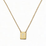 An Engraved Initial Necklace Letter P by Skōsh Jewelry, featuring a small rectangular tag engraved with the letter P on a fine gold chain, displayed against a white background.