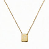 An Engraved Initial Necklace Letter P by Skōsh Jewelry, featuring a small rectangular tag engraved with the letter P on a fine gold chain, displayed against a white background.