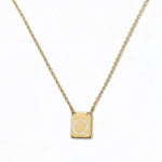 An Engraved Initial Necklace Letter Q by Skōsh Jewelry, featuring a small rectangular tag engraved with the letter Q on a fine gold chain, displayed against a white background.
