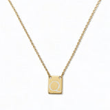 An Engraved Initial Necklace Letter Q by Skōsh Jewelry, featuring a small rectangular tag engraved with the letter Q on a fine gold chain, displayed against a white background.