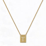 An Engraved Initial Necklace Letter T by Skōsh Jewelry, featuring a small rectangular tag engraved with the letter T on a fine gold chain, displayed against a white background.