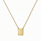 An Engraved Initial Necklace Letter W by Skōsh Jewelry, featuring a small rectangular tag engraved with the letter W on a fine gold chain, displayed against a white background.