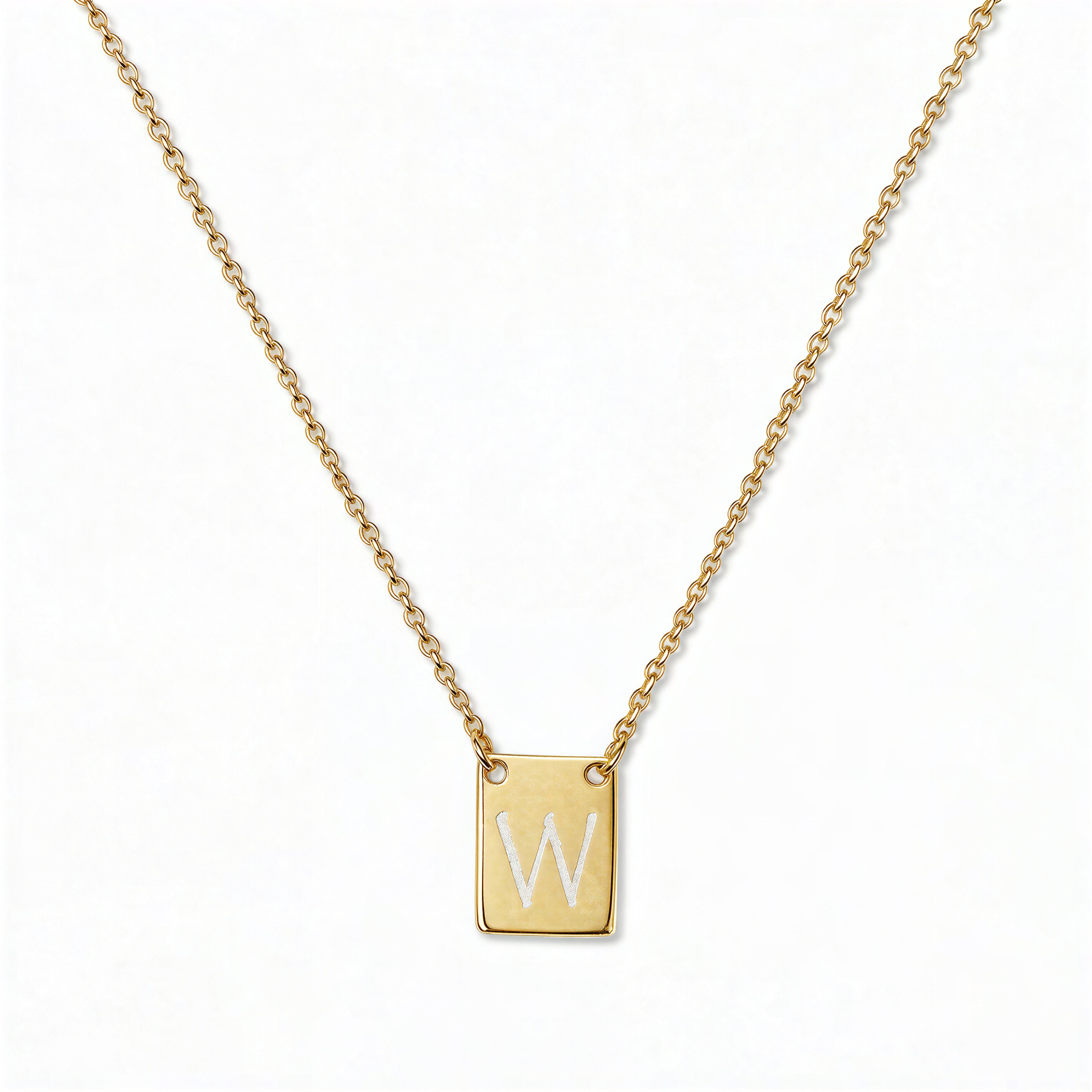 An Engraved Initial Necklace Letter W by Skōsh Jewelry, featuring a small rectangular tag engraved with the letter W on a fine gold chain, displayed against a white background.