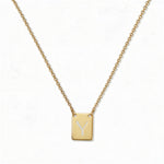 An Engraved Initial Necklace Letter Y by Skōsh Jewelry, featuring a small rectangular tag engraved with the letter Y on a fine gold chain, displayed against a white background.