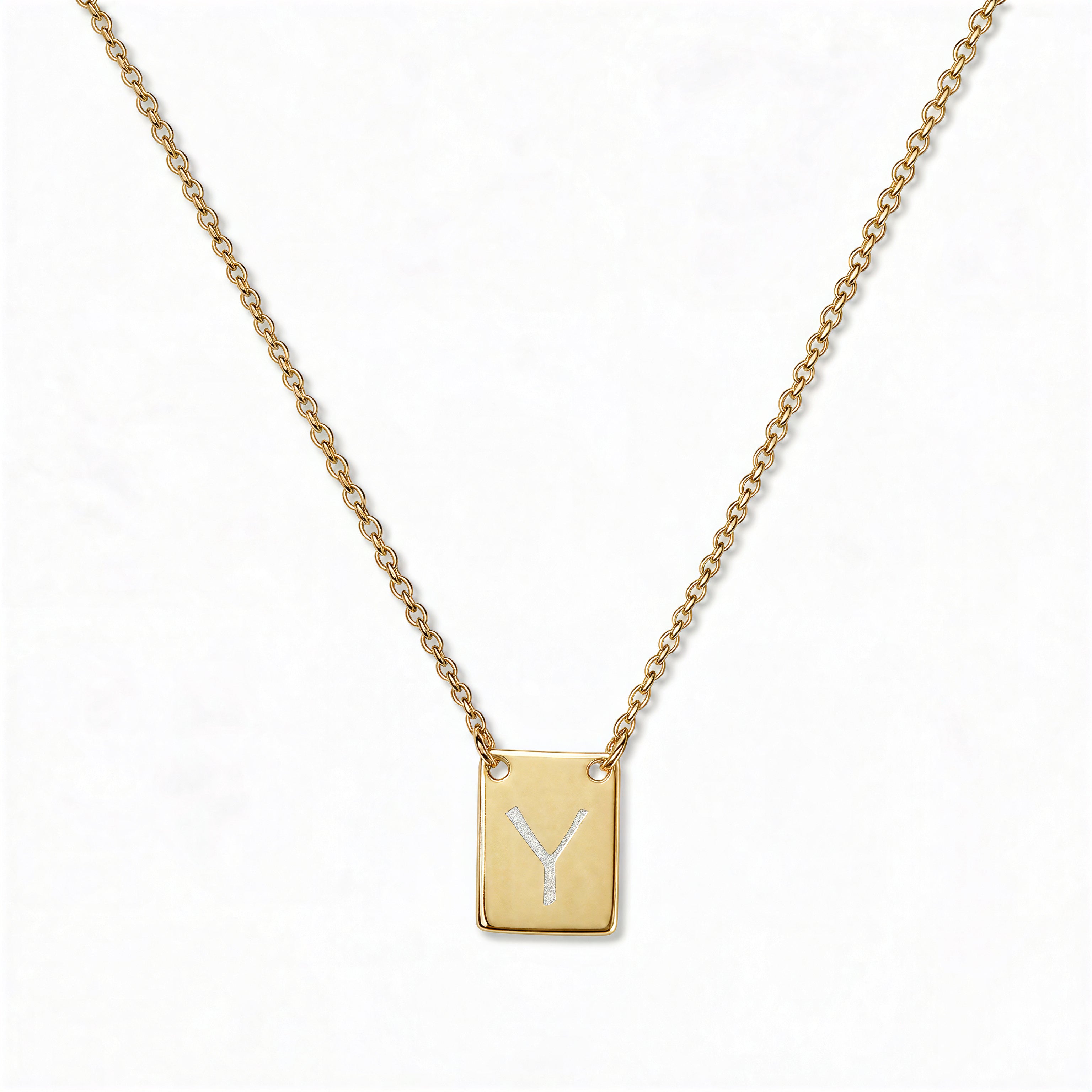 An Engraved Initial Necklace Letter Y by Skōsh Jewelry, featuring a small rectangular tag engraved with the letter Y on a fine gold chain, displayed against a white background.
