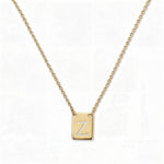 An Engraved Initial Necklace Letter Z by Skōsh Jewelry, featuring a small rectangular tag engraved with the letter Z on a fine gold chain, displayed against a white background.