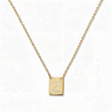 An Engraved Initial Necklace Letter Z by Skōsh Jewelry, featuring a small rectangular tag engraved with the letter Z on a fine gold chain, displayed against a white background.