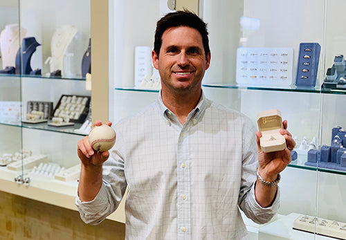 Ben Haddox smiling in a jewelry store holding a baseball and an open ring box